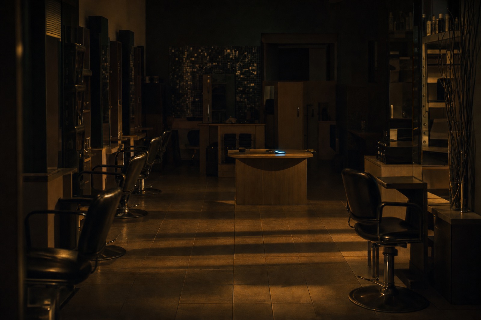 Inside the empty salon after hours, streetlight across the floor and chairs.